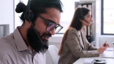 İnternette asistanlık yapan kulaklık takan Hintli erkek bilgi işlem elemanı portresi. Çağrı sırasında konuşmak, müşteri ya da müşteriyle iletişim kurmak. Çevrimiçi yardım kavramı.