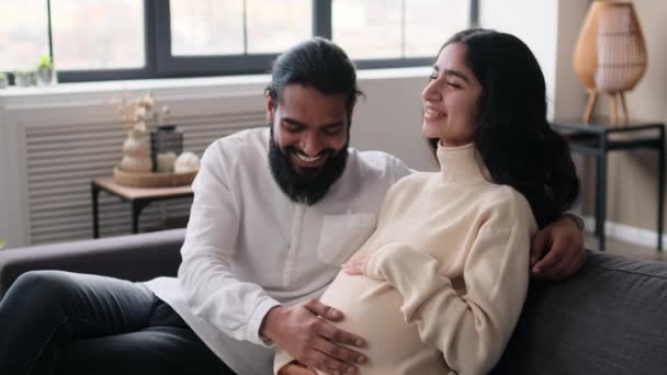 已婚的印度家庭 妻子和丈夫 等待分娩 在家里抚摸怀孕的肚子 在沙发上放松 为人父母的准备 怀孕时间概念 — 图库视频影像