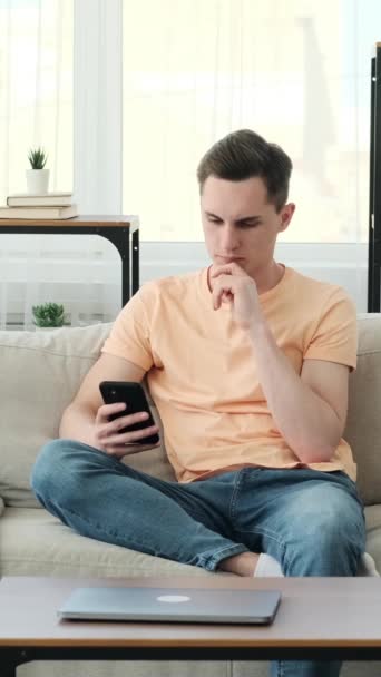 Homem Caucasiano Atencioso Senta Sofá Confortável Absorvido Seu Smartphone Com — Vídeo de Stock