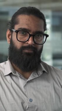 Bu portre, gözlük takan ve sıcak bir gülümseme gösteren Hintli bir girişimci resmediyor. Onun dostça ifadesi güven ve yakınlık yayar..