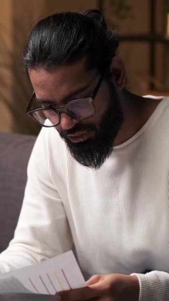 Intialainen Liikemies Ahkerasti Taipumus Paperityötä Istuessaan Sohvalla Hänen Keskittyneet Ilmeensä — kuvapankkivideo