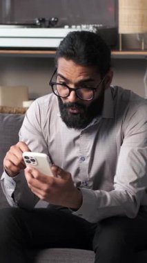 Kanepede oturan Hintli adam telefonla cesaret verici haberler alıyor. İfadeler mutluluk ve heyecanla parlıyor, pozitif bir aydınlanma sahnesi yaratıyor..