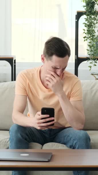 Biały Mężczyzna Reaguje Głębokim Obrzydzeniem Korzystając Telefonu Zaciszu Swojego Domu — Wideo stockowe