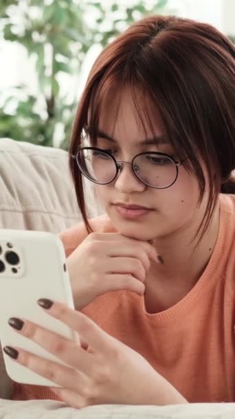 Descansando Sofá Una Adolescente Vuelve Cautivada Por Teléfono Cuando Repente — Vídeo de stock
