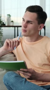 Kafkasyalı kararlı bir adam kanepede oturuyor, düşüncelerine ve görevine dalmış. Elinde kalemle ve yüzünde kasıtlı bir ifadeyle özenle parlak bir deftere yazar..