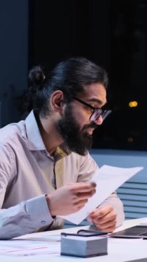 Gece ofisinin sakinliğinde neşeli bir Hintli işadamı işle ilgili bir video görüşmesi yapıyor. Mutlu ifadeler ve meşgul tavırlar pozitiflik ve adanmışlığı ifade eder..