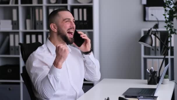 Joven Adulto Caucásico Freelancer Masculino Hablando Por Teléfono Celebrando Éxito — Vídeo de stock