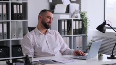 Kafkasyalı iş adamı, ofis molasında görüntülü konuşma yapıyor, işyerinde dinleniyor. Arkadaşlarla konuşmak, tatil ya da hafta sonu planı yapmak. Çevrimiçi iletişim ve sohbet kavramı.