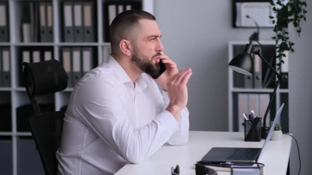 Seriöse Kaukasische Männliche Büroangestellte Berät Kunden Während Eines Telefonats Sitzt — Stockvideo