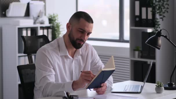 Усміхнений Кавказький Бізнесмен Працює Календарем Пише Розклад Організаторі Готує Чек — стокове відео