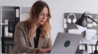 Bilgisayarda yazı yazan, ofiste çalışan, odaklanmış beyaz kadın serbest yazar. Mesaj ve mesajlaşma, iş e-postasında cevap, çevrimiçi iletişim kavramı.
