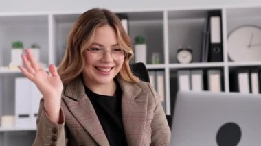 Beyaz kadın ofis çalışanı görüntülü konuşma yapıyor, dizüstü bilgisayar kullanıyor, ofis molasında dinleniyor. Meslektaşlarla, arkadaşlarla ya da ailelerle konuşmak, tatil planlamak..
