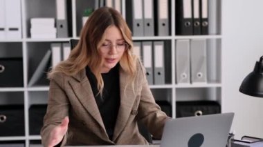 İnternetteki toplantı sırasında meslektaşlarına ya da iş arkadaşlarına bağıran Kafkasyalı kadın, ofiste belgelerle çalışıyor. Şef çalışanlarına bağırıyor.
