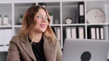 İş yerinde arkadaşlarıyla ya da ailesiyle sohbet eden gülümseyen iş kadını ara verip güler, ofiste masa başında oturur. Hafta sonu ya da tatil planlama.