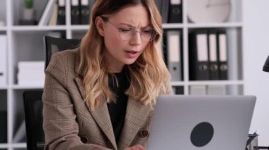 Kederli Kafkasyalı iş kadını iş başarısızlığı yaşıyor, bilgisayarla meşgul, modern ofiste masa başında oturuyor. Hata, arıza. İş gerginliği ve stres.