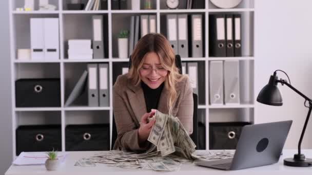 Веселая Улыбающаяся Белая Женщина Бросающая Деньги Празднующая Финансовое Благосостояние Сидит — стоковое видео