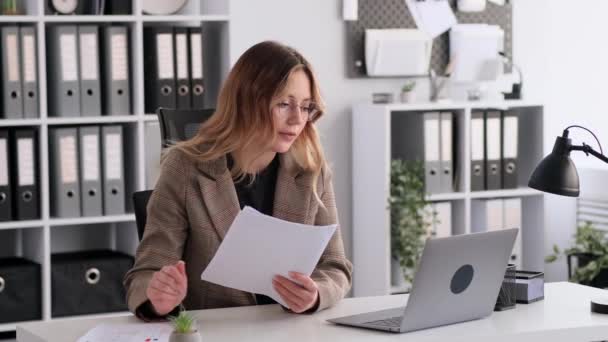 女商人使用笔记本电脑参加视频通话 处理文件 坐在办公室的办公桌前 老板在和同事说话在线会议或协商概念 — 图库视频影像