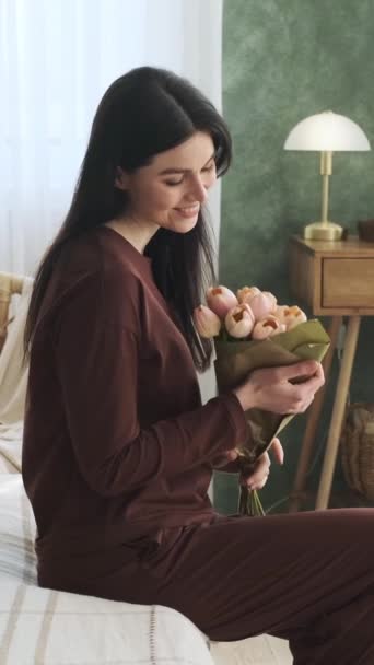 ハッピーコーカサス人女性は 自宅で花束を嗅ぎ 贈り物やプレゼントを楽しんでいます 驚きと祝福を喜びました バーティカルビデオ — ストック動画