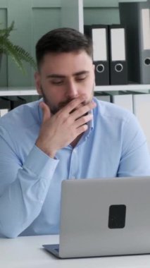 Ciddi bir beyaz erkek yönetici ofiste dizüstü bilgisayarla çalışıyor. Profesyonel muhasebe, internette iş araştırması. Dikey video.