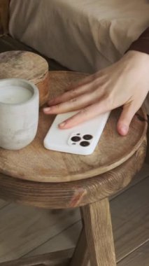 Uyuyan ve üzgün Kafkasyalı kadın evde uyuyor, sabah uyandığında telefon mesajı bildiriyor. Mutsuz sabah konsepti. Dikey video.