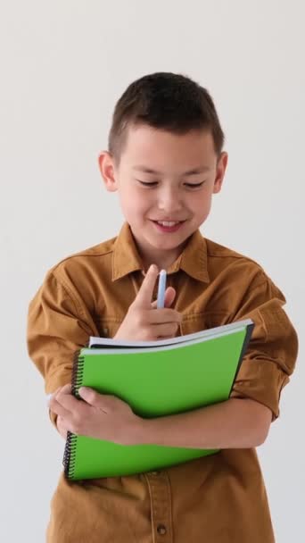 Portrait Cheerful Asian Young Schoolboy Writing Notepad Doing Homework White — Stock Video
