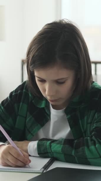 Konzentrierter Kaukasischer Junge Schreibt Hausaufgaben Notizbuch Und Sitzt Hause Schreibtisch — Stockvideo