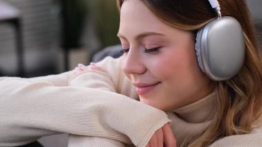 Evinde kulaklıkla müzik dinleyen mutlu ve arkadaş canlısı beyaz bir kadının portresi. Boş zaman ve emekliliğin tadını çıkarıyorum..