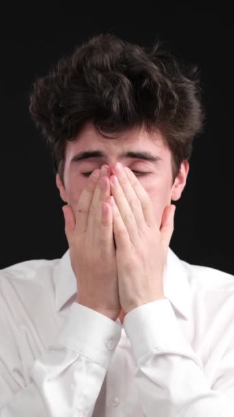 一个悲伤的 忧郁的高加索年轻人的画像 在黑色背景下哭泣 情绪压力的概念 垂直录像 — 图库视频影像