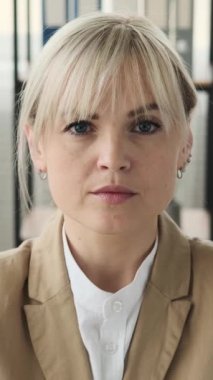 Ofisteki ciddi bir beyaz iş kadınının portresini yakından çek. Kadın girişimci, danışman, iş adamı gibi. Dikey video.