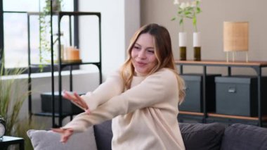 Hafta sonu boş vakitlerinde evde dans eden, kanepede dinlenen, müzik dinleyen mutlu beyaz kadın. Boş zamanlarımda eğleniyorum..