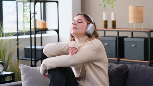 Melancholijna Beznadziejna Biała Młoda Kobieta Słuchająca Muzyki Słuchawkach Siedząca Kanapie — Wideo stockowe