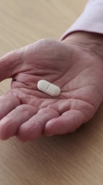 Yetişkin, beyaz bir kadının el ele tutuşma tabletlerini yakından çek. Sağlık ve medikal ya da farmakoloji reçetesi konsepti. Dikey video.