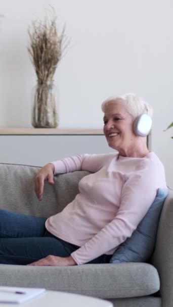 Madura Mujer Caucásica Feliz Escuchando Música Auriculares Inalámbricos Relajarse Sofá — Vídeo de stock