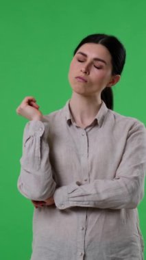 Düşünceli ve düşünceli Kafkasyalı kadın yeşil arka planda çözüm ya da soru cevabı bulma stratejisi düşünüyor. Dikey video.