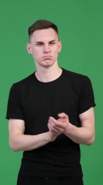 Memnun ve gururlu beyaz adam yeşil arka planı onaylamak için el çırpıyor. Anlaşma, saygı, tebrik. Dikey video.