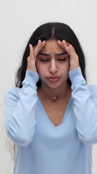 不健康で 白い背景の頭痛に苦しんでいるインドの女性を動揺させます フラストレーション 病気の概念 バーティカルビデオ — ストック動画