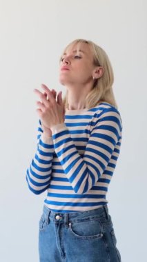 Beyaz arka planda üzüntülü bir kadın. Stres ve duygusal gerilimden muzdarip kötü ruh sağlığı kavramı. Dikey video.