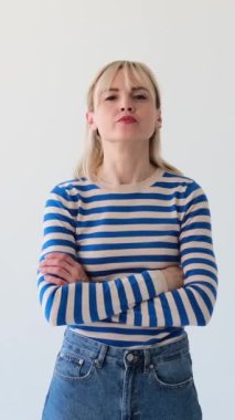 Tatmin olmamış, kızgın ve agresif bir kadının portresi. Beyaz arka planda yumruklarla tehdit ediyor. Duygusal stres yüzünden. Dikey video.