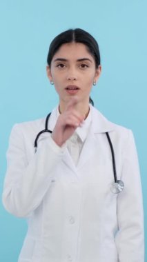 Sert, beyaz kadın doktor ya da pratisyen doktor gizlilik ya da mahremiyeti korumak için mavi arka planda duruyor. Dikey video.