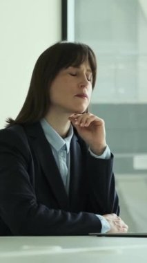 Ofiste çalışırken dizüstü bilgisayar, iş stratejisi ya da proje kullanan konsantre beyaz kadın yönetici. Dikey video.