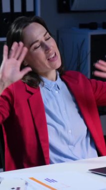 Ofisteki çevrimiçi video görüşmesi sırasında gülen beyaz kadın ofis çalışanı tatilde arkadaşlarıyla konuşuyor. Dikey video.