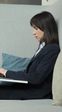 Ofiste çalışırken laptopunu kullanan orta yaşlı, arkadaş canlısı beyaz iş kadını. Planlama işi. Dikey video.