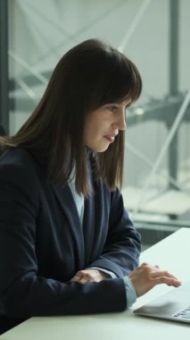 Mutlu orta yaşlı kadın ofis çalışanı ofiste çalışırken iyi haberleri kutluyor ve alkışlıyor. Zafer ya da zafer kavramı. Dikey video.