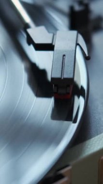 Dönüş plağı ve pikap iğnesi olan retro vinil müzik çaların yakın plan çekimleri. Klasik ses çalar ekipmanı. Dikey video.