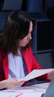 Kafkasyalı orta yaşlı serbest çalışanın gece ofisinde dizüstü bilgisayarla çalışırken evrak işlerinde hata yapmasına şaşırdım. Dikey video.