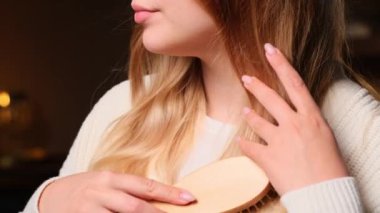 Kafkasyalı genç bir kadının ellerinin ipeksi saçlarını fırçayla taramasını. Saç bakım ve güzellik rutin konsepti.