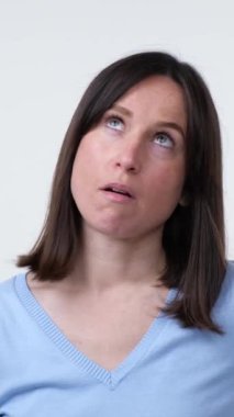 Sıkıntılı ve bunalımlı orta yaşlı beyaz kadın beyaz arka planda utançla facepalm hareketi yapıyor. Hayal kırıklığı kavramı. Dikey video.