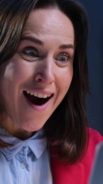 Ofiste dizüstü bilgisayarla çalışırken başarıyı kutlayan ve evet diyenlerin mutlu beyaz kadın portresi. Dikey video.