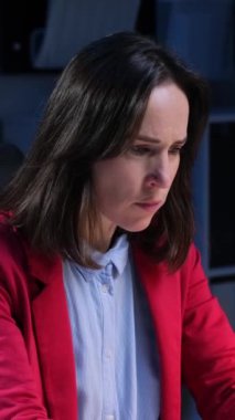 Ofiste çalışan orta yaşlı, beyaz, soğuk algınlığı ve gripten muzdarip bir kadın. Virüs ya da alerji kavramı. Dikey video.