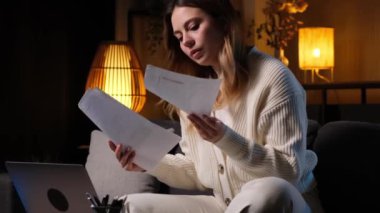 Uzaktan kumandalı bilgisayar ve belgelerle çalışan ciddi bir beyaz kadın. Raporları ve bütçeyi incele, bilgi veya verileri analiz et.